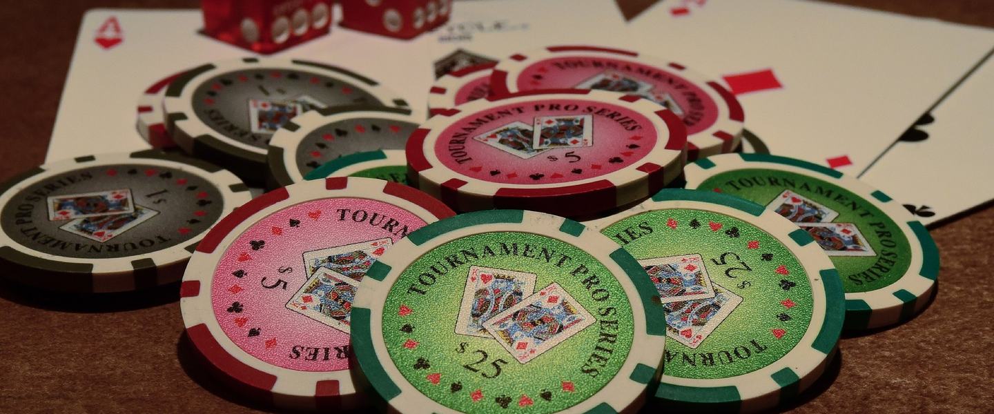 Poker chips, playing cards and red dice on a table